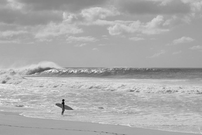 Surfer standing on the beach, North Shore, Oahu, Hawaii, USA